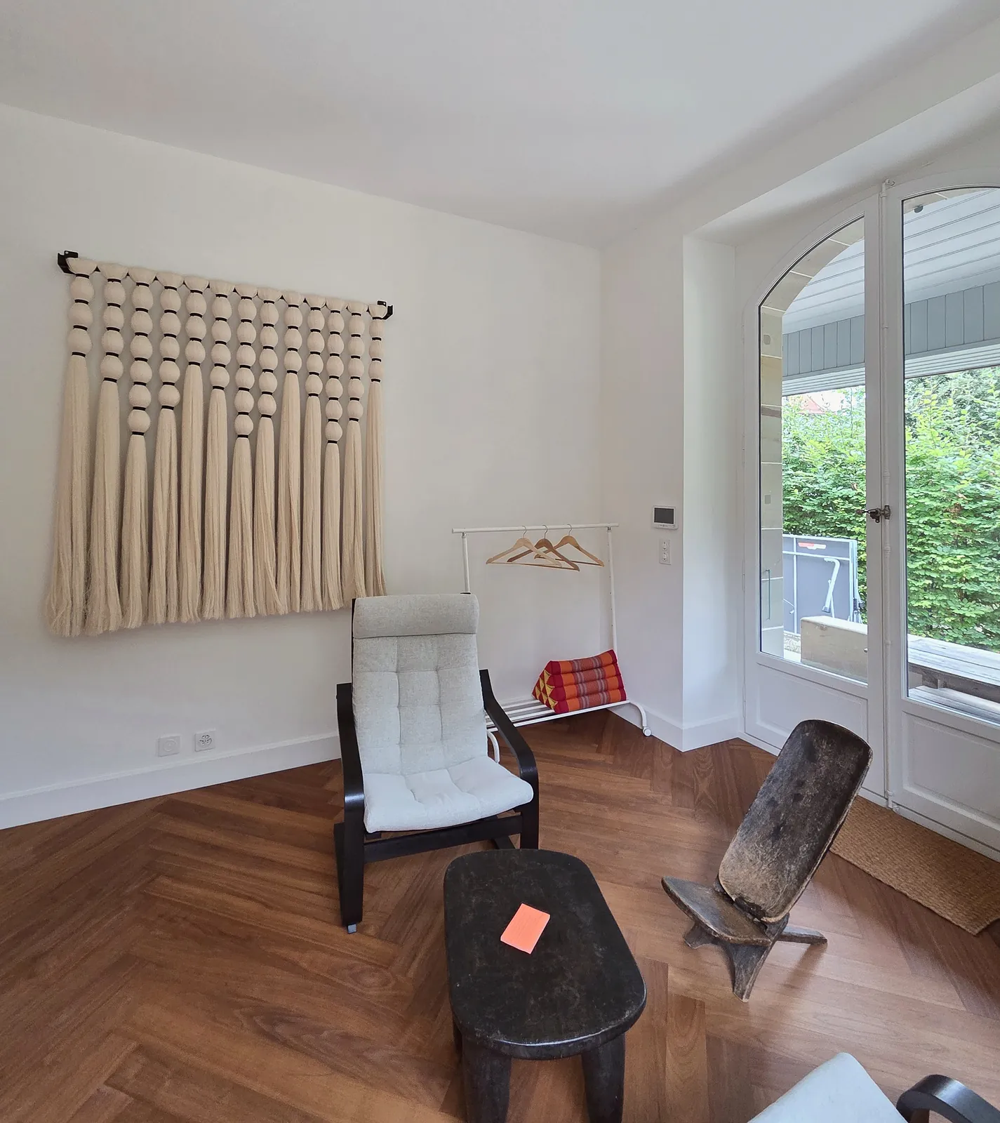 Espace de détente du cabinet d'hypnose HypnoVibes à Lausanne, parquet en point de Hongrie et lumière naturelle