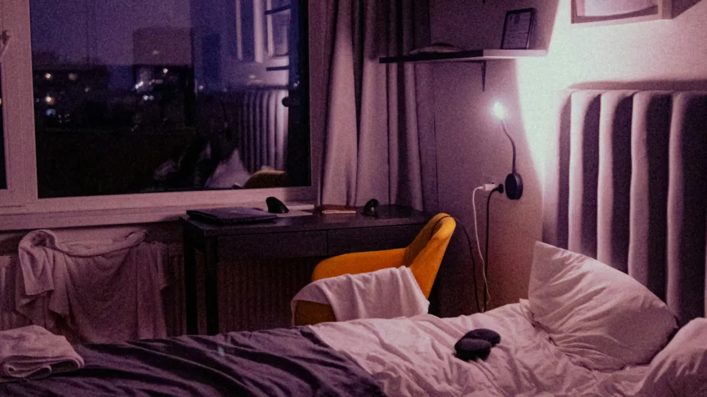 Chambre dans la pénombre, réveil allumé au milieu de la nuit : hypnose et sommeil à Lausanne